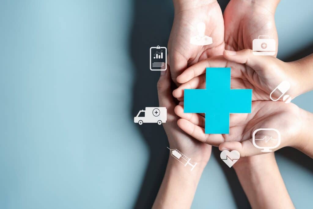 Private oder gesetzliche Krankenversicherung für Beamte – Hände halten medizinische Symbole