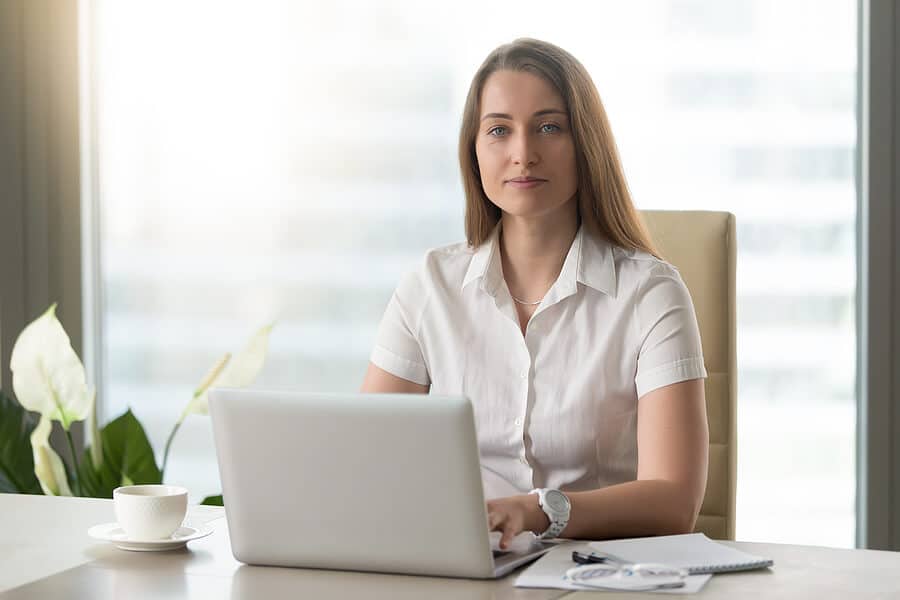 Frau sitzt vorm Laptop und arbeitet